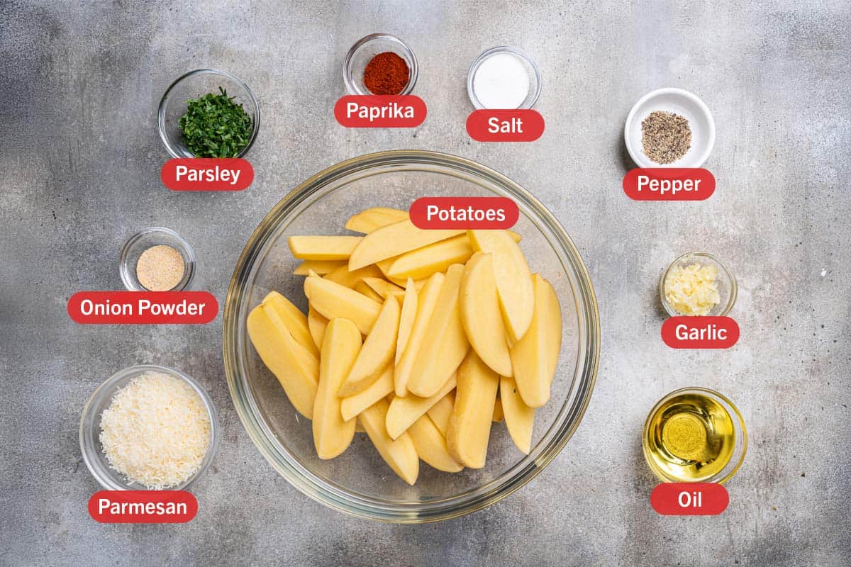 Image of all the ingredients needed for the preparation of this recipe, specifically: potatoes, paprika, salt, pepper, garlic, oil, parmesan, onion powder, and parsley.