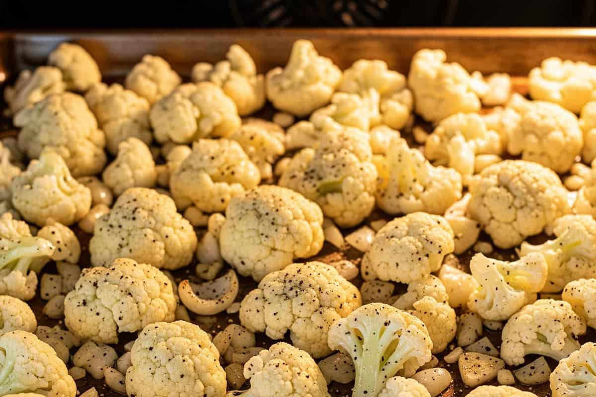 Cauliflower on a baking sheet inside the oven.