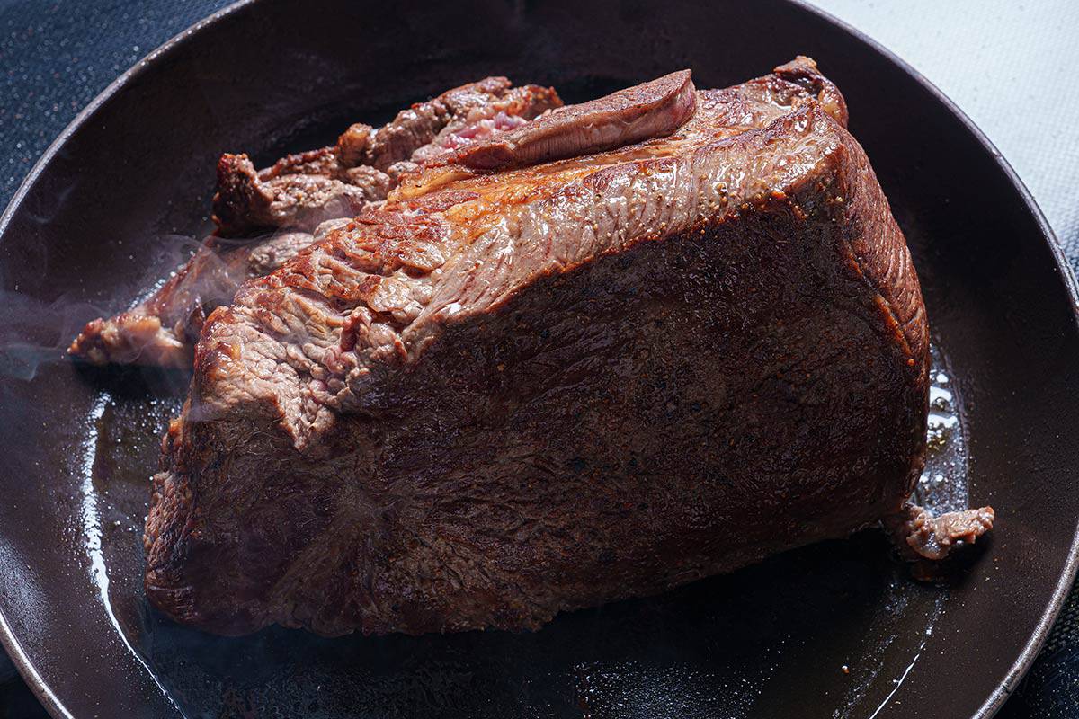 An image of the beef chuck being seared in the skillet until it is browned.