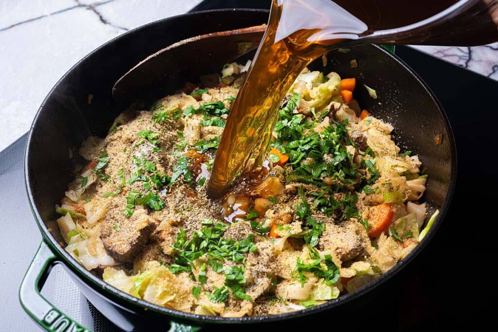 beef and veggies in a pot garnished with parsley