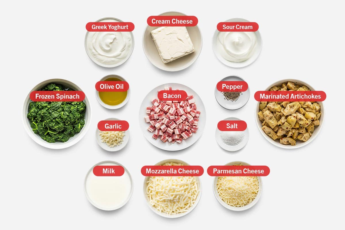 Top shot of ingredients: greek yogurt, cream cheese, sour cream, frozen spinach, olive oil, garlic, milk, bacon, mozzarella cheese, pepper, salt, parmesan cheese, and marinated artichokes.