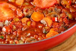 wine being poured into pan with vegetables