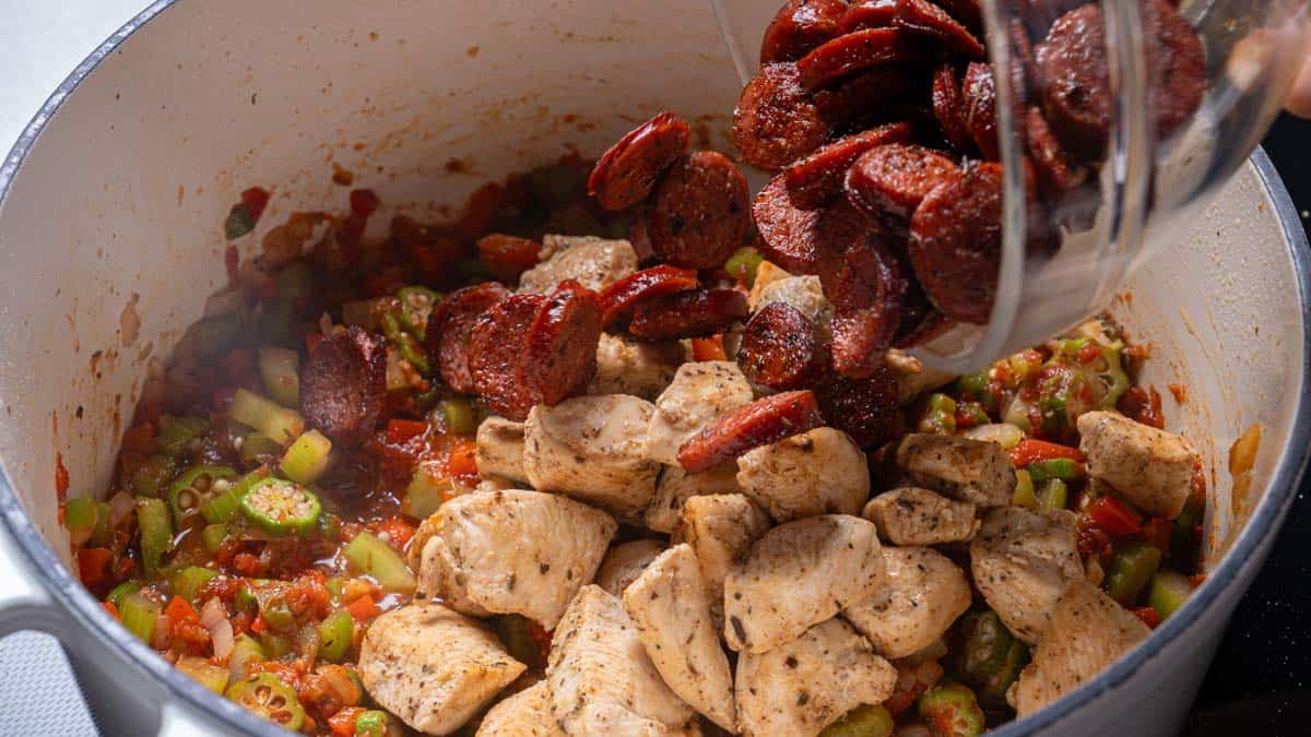 adding the sausage in the pan with all the ingredients