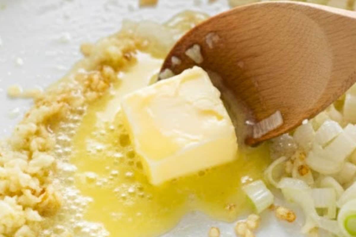 Melt the butter in a medium pot over medium heat. Sauté the white parts of the green onions and garlic in a pan.