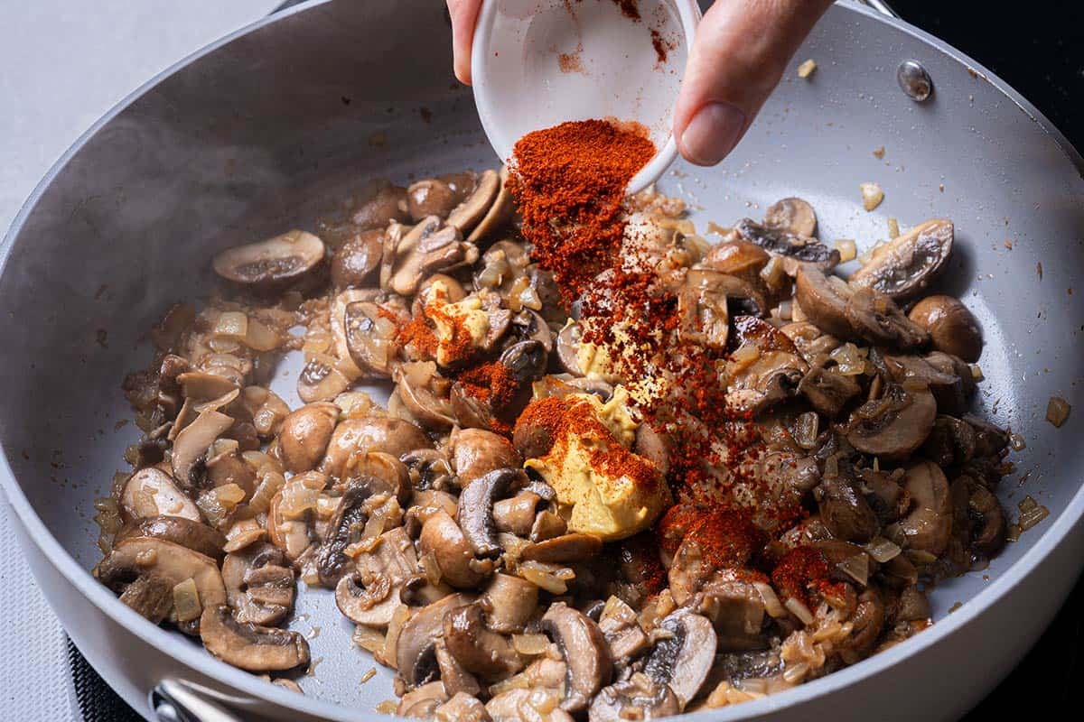 mushroom and various seasonings being sauted in a pan