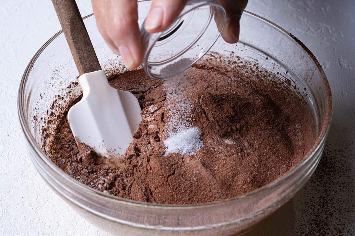 Image showing salt being added to the dry ingredients before gently folding them together.