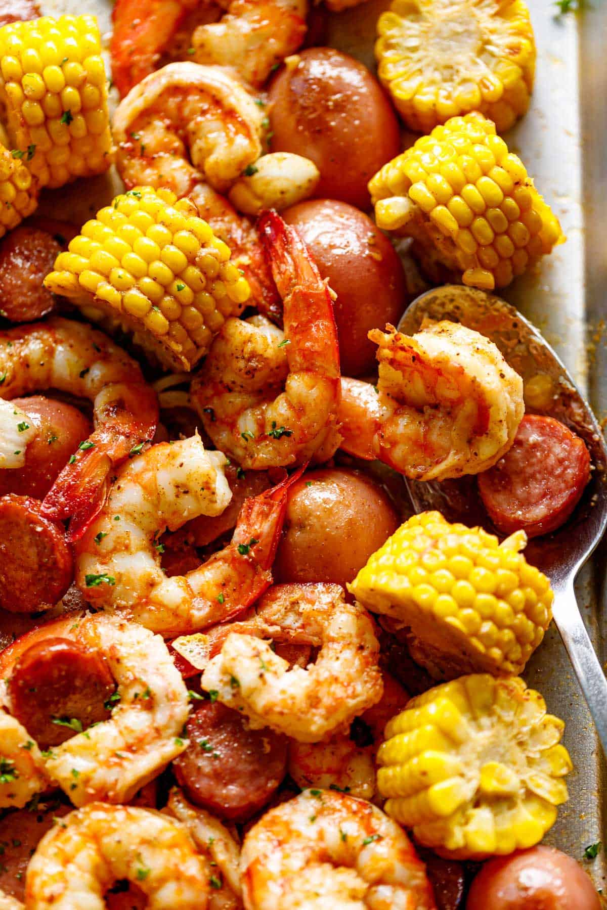 Shrimp Boil smothered in garlic butter and Old Bay seasoning made easy in the oven. Ready in 30 minutes! | cafedelites.com