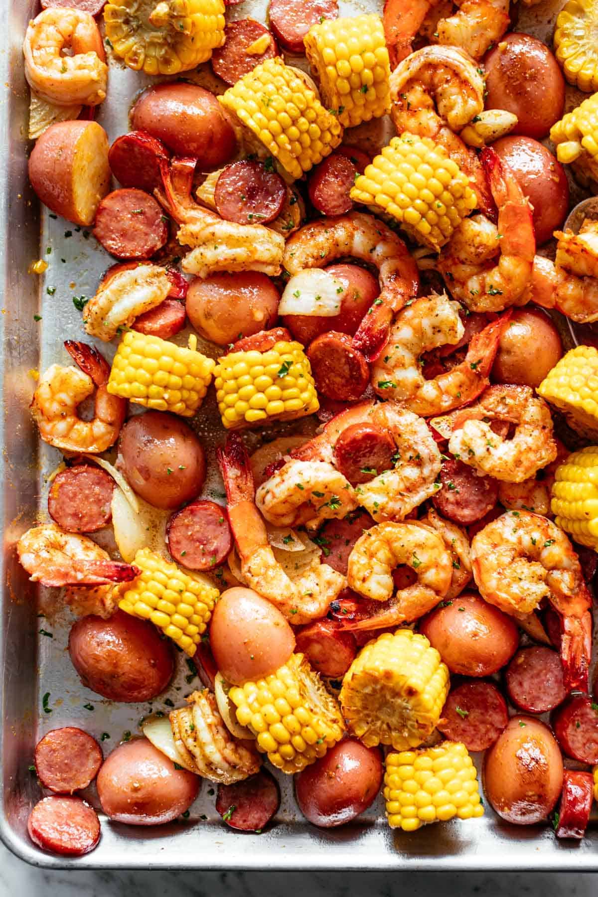 Shrimp Boil smothered in garlic butter and Old Bay seasoning made easy in the oven. Ready in 30 minutes! | cafedelites.com