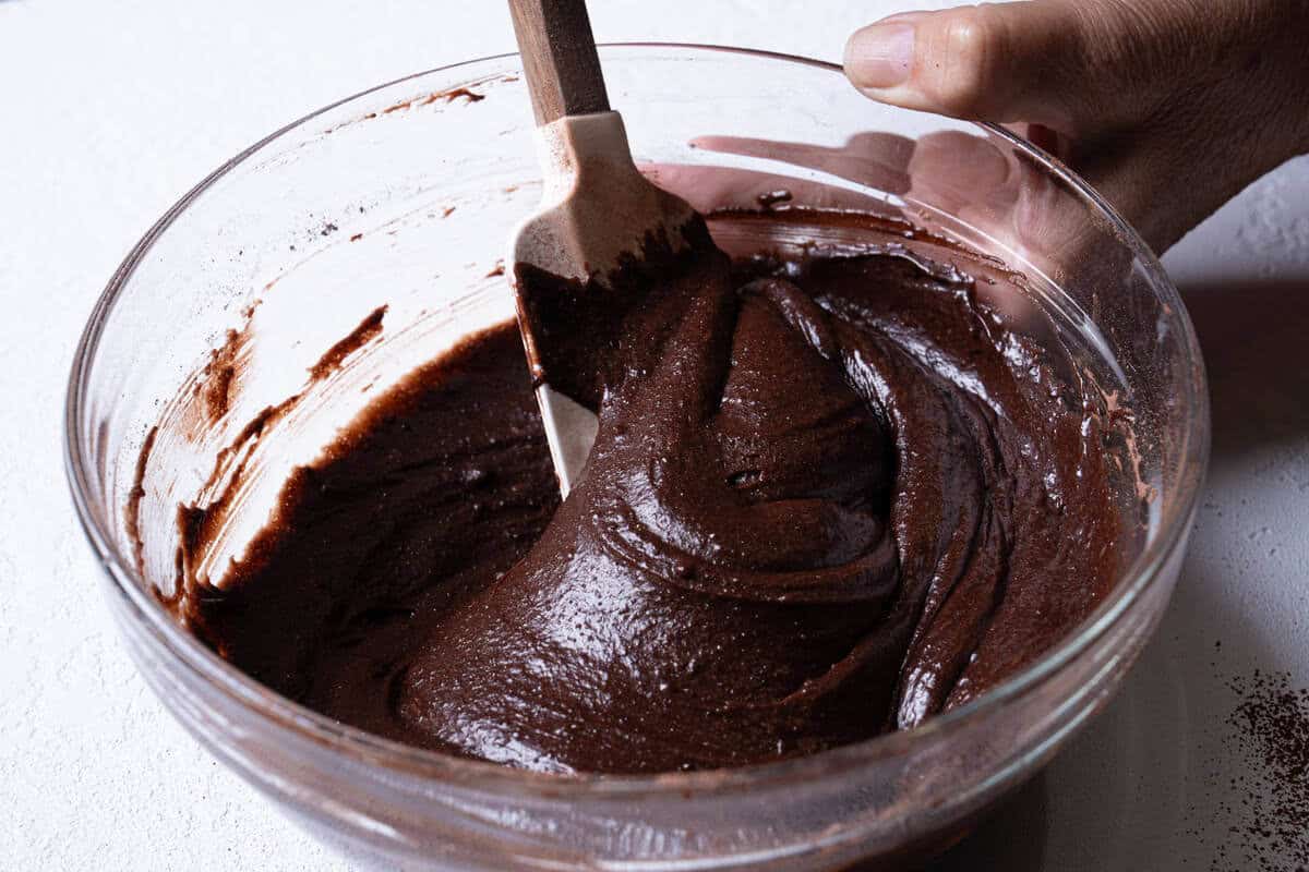 Dry ingredients being gently folded together with wet ingredients until just combined.