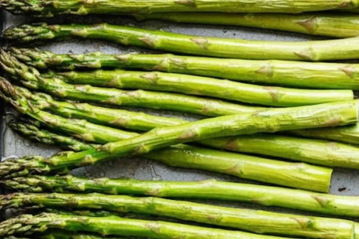 Start by preheating the oven at 425 degrees and greasing your baking sheet with nonstick cooking oil spray. Arrange the asparagus spears on the sheet
