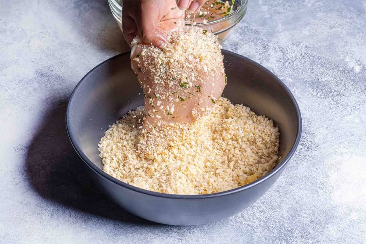 chicken being combined with breadcrumbs