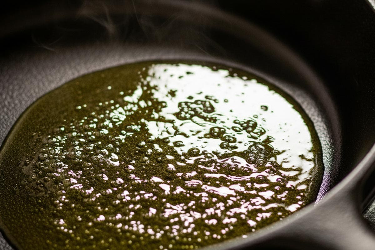Shimmering olive oil in a pan.