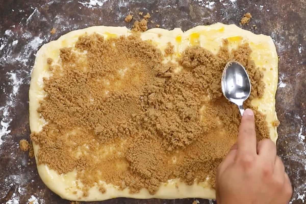 Spreading the sugar over the dough.