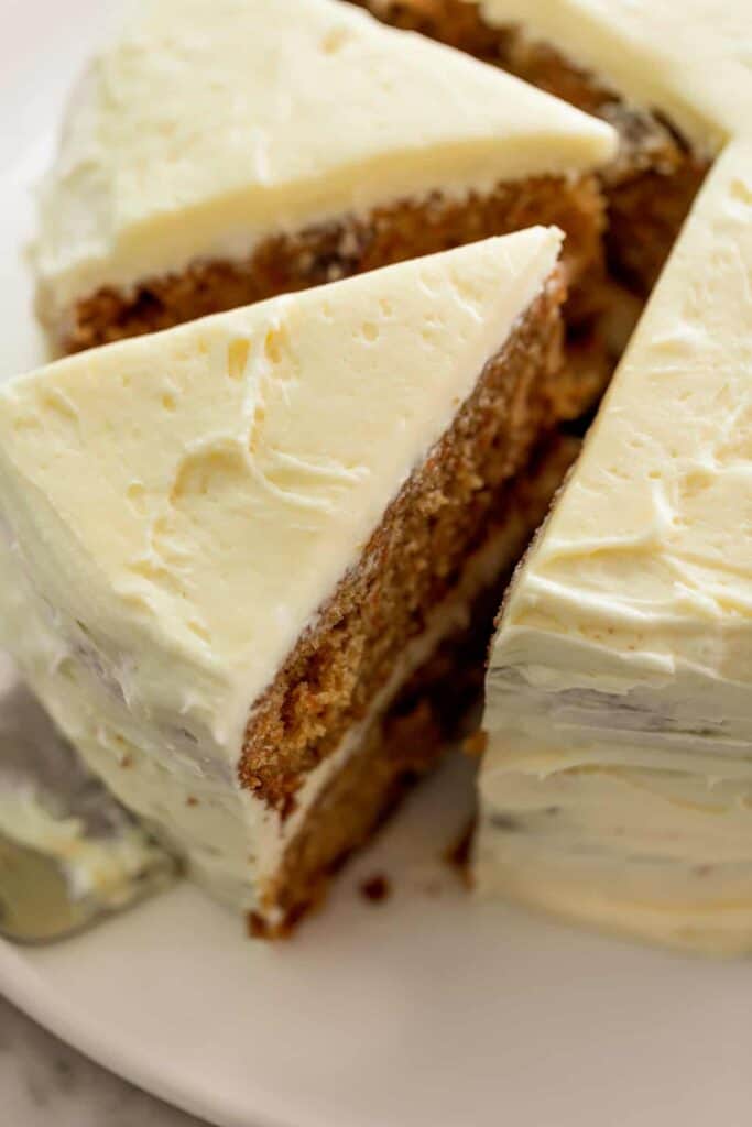 Super soft Carrot cake cut into large triangle slices on a serving plate.