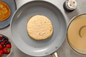 pancake batter in a pan with bubbling surface
