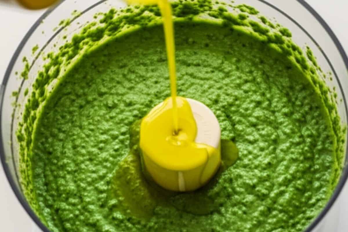 With the processor running, pour the olive oil.