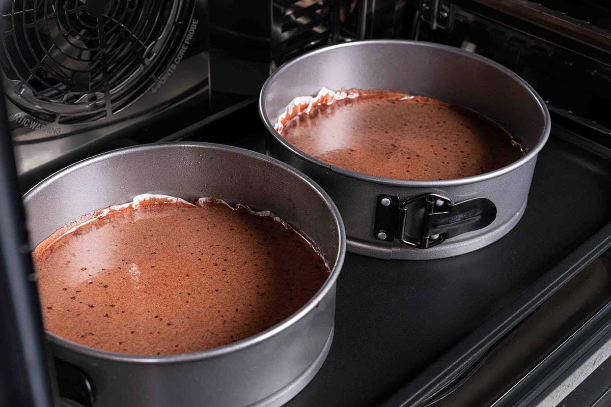 two pans filled with cake mix in the oven