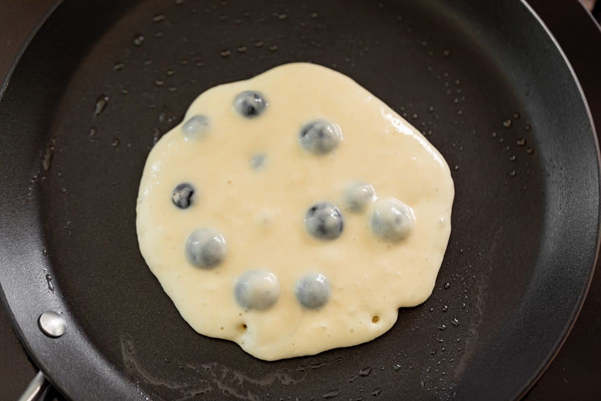 Cooking blueberry pancakes in a black nonstick pan | cafedelites.com