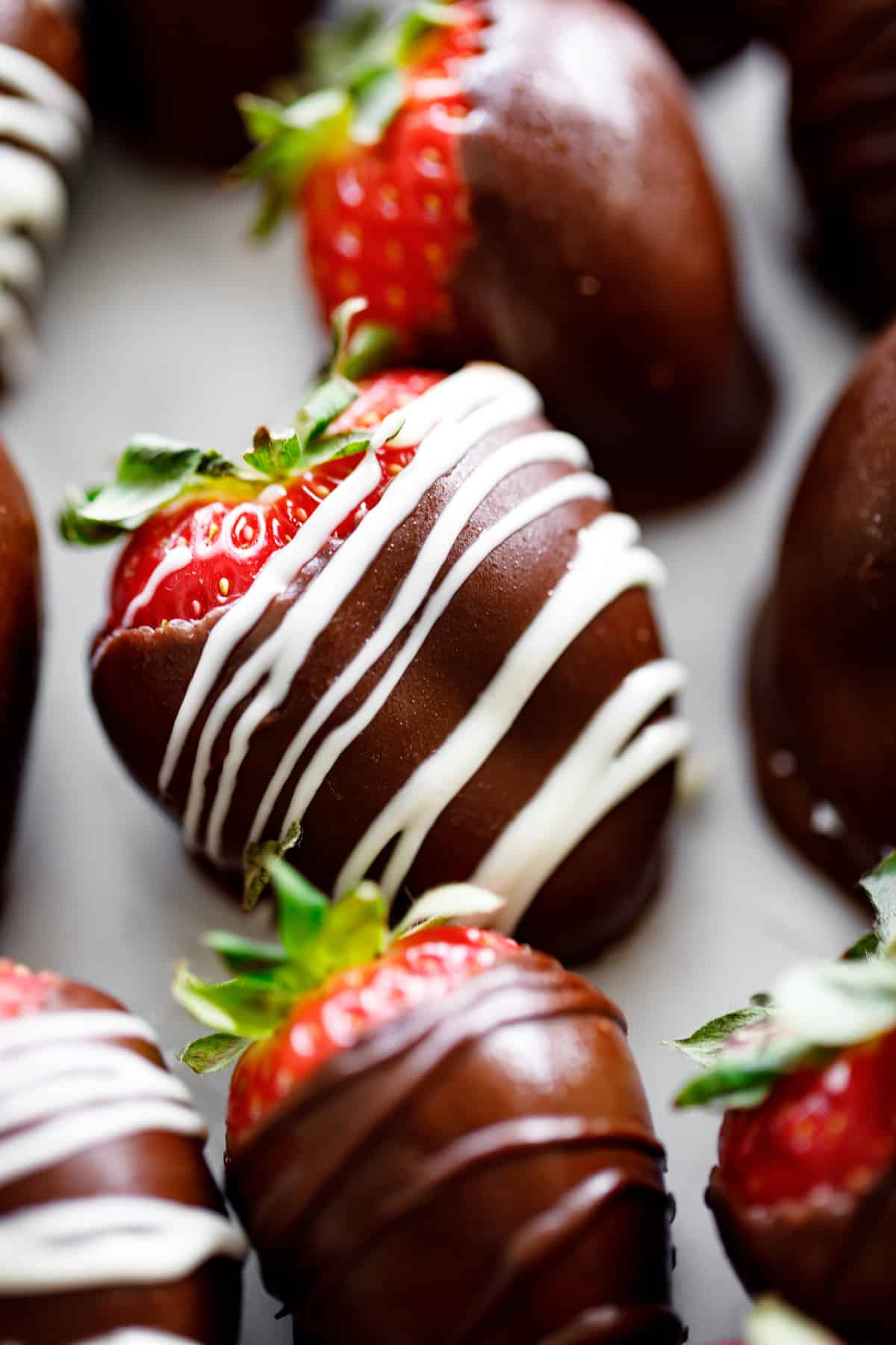 A close up photograph of a chocolate covered strawberry.