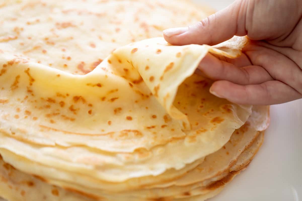 Holding a crepe on the top of a stack.