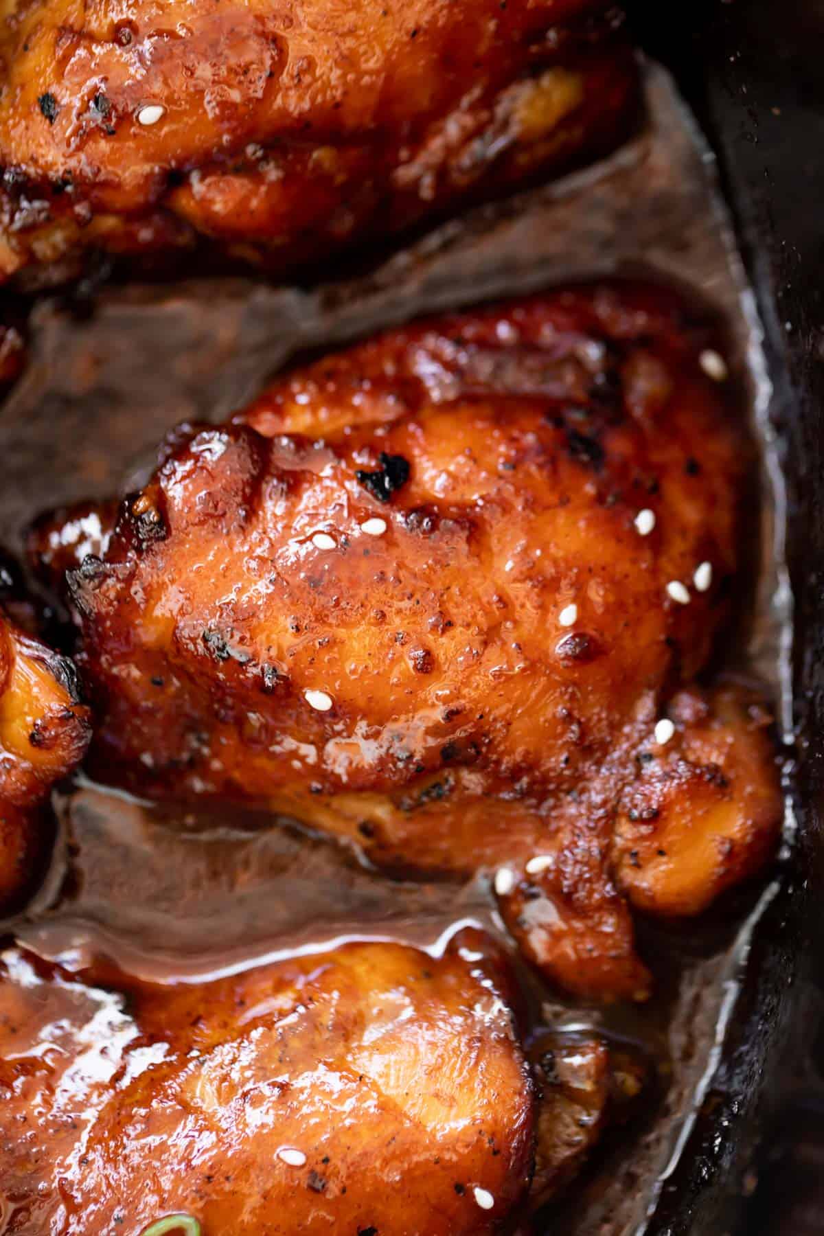 A close-up of a chicken thigh cooked in a honey and garlic sauce.