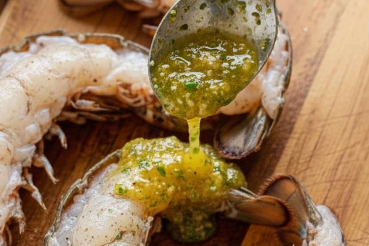 Seasoning the tails with the garlic butter mixture.