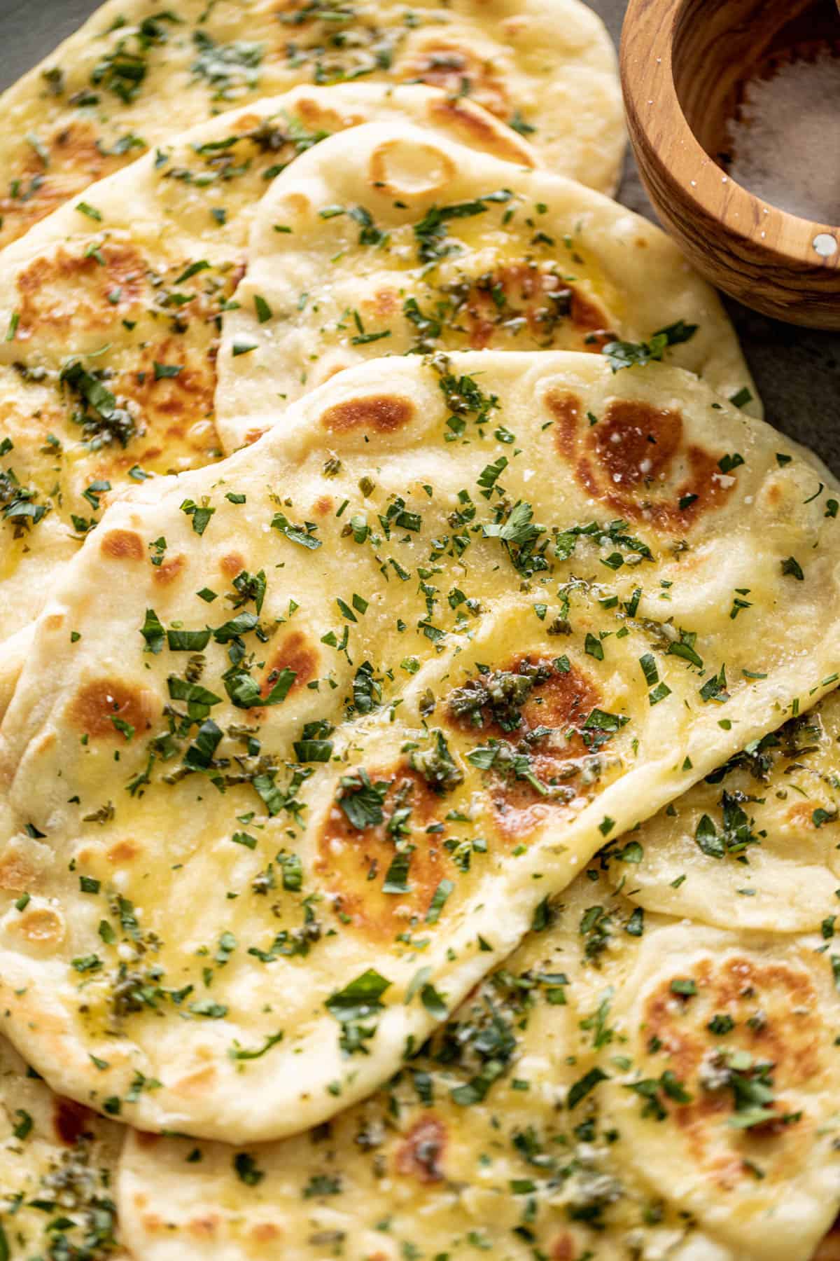 Buttery Garlic Naan Breads on a plate with garlic butter and fresh chopped cilantro