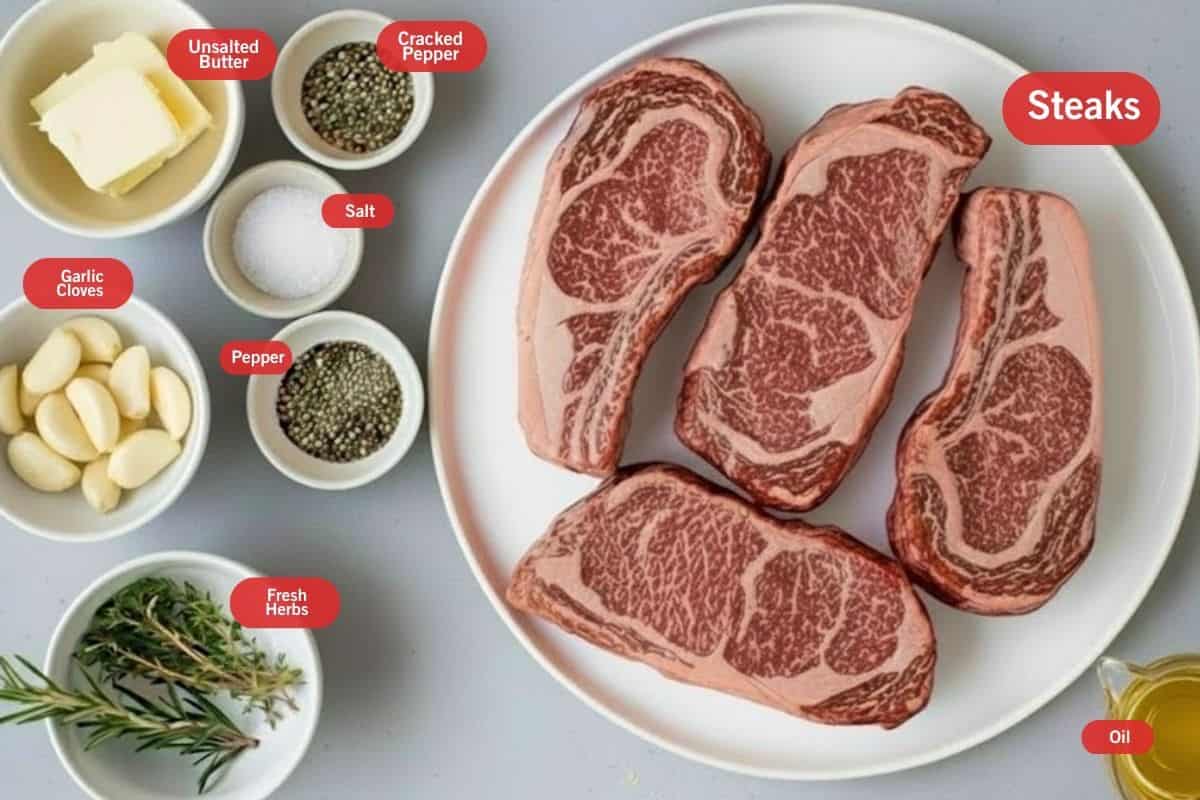 Flat lay photo of ingredient shot of steaks, unsalted butter, crushed pepper, salt, pepper, fresh herbs, garlic cloves, oil - 2