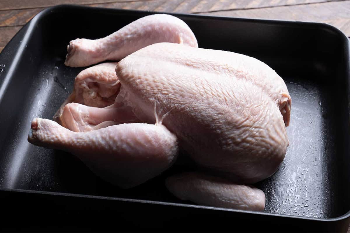 Image of the chicken laying on a baking tray after being cleaned and prepared.