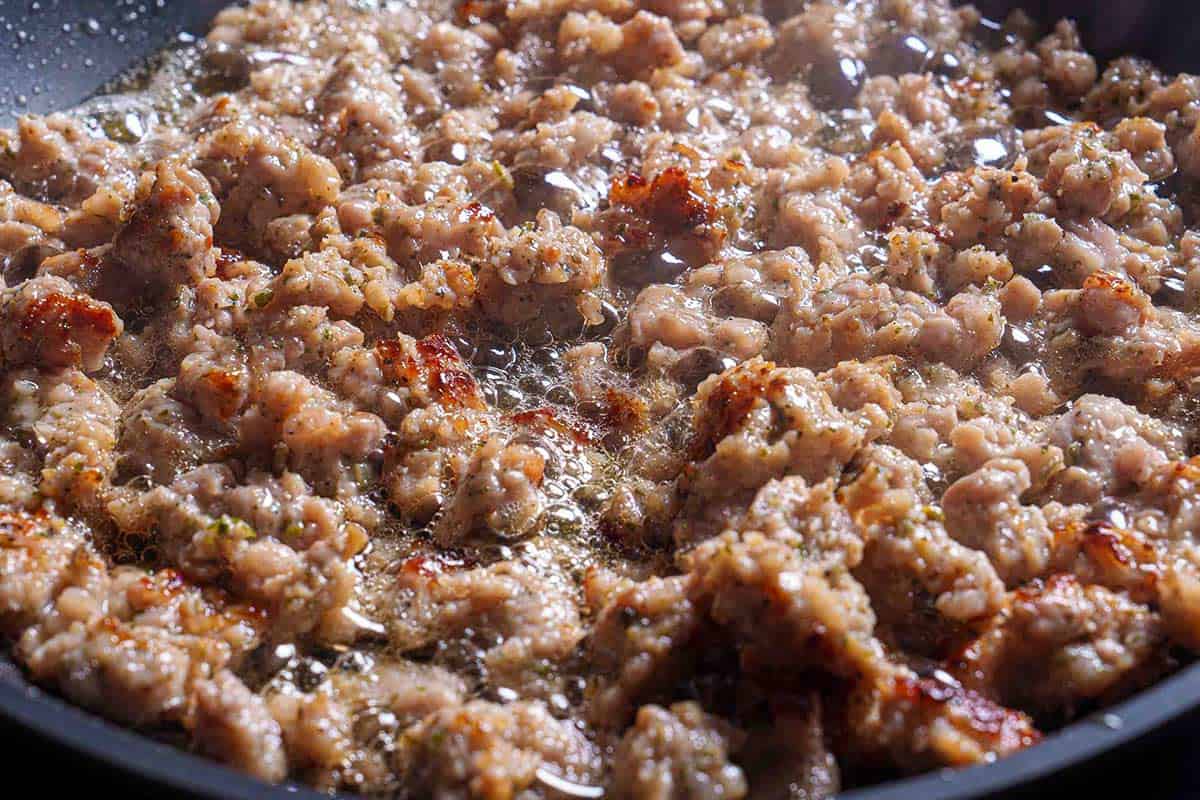 Step 2: The image shows the sausage being sautéed and browned in a skillet over medium heat.