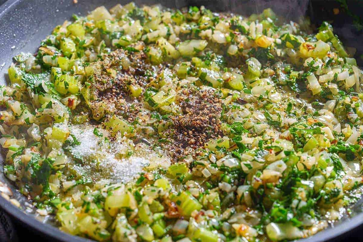 Step 3: The image shows onions, celery, and garlic cooked over medium heat until they are softened and translucent.