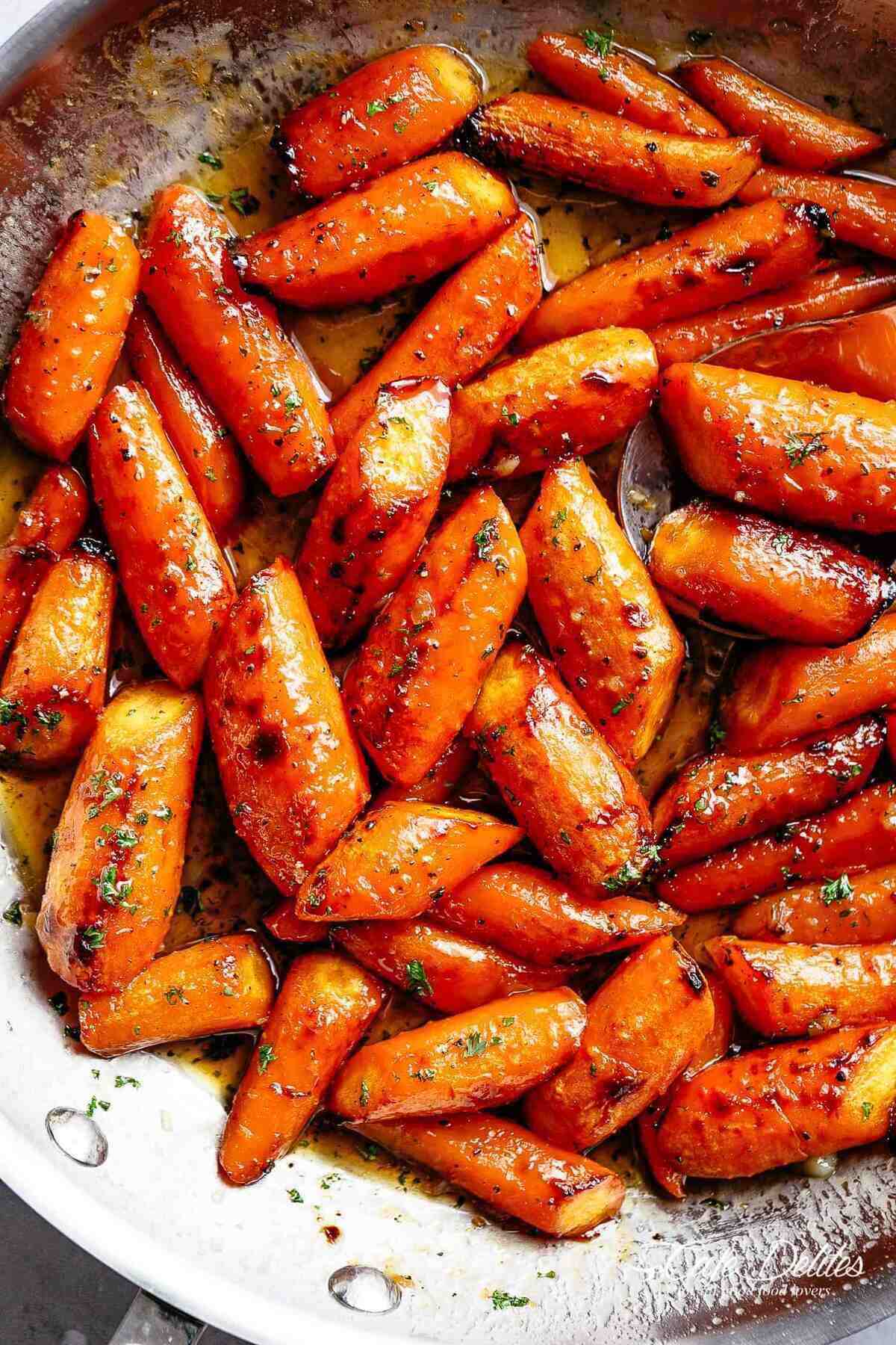 Close up image of roasted carrots coated in honey garlic butter sauce.