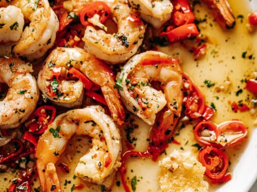 Image of a white plate with Chili Garlic Butter Shrimp in a buttery sauce