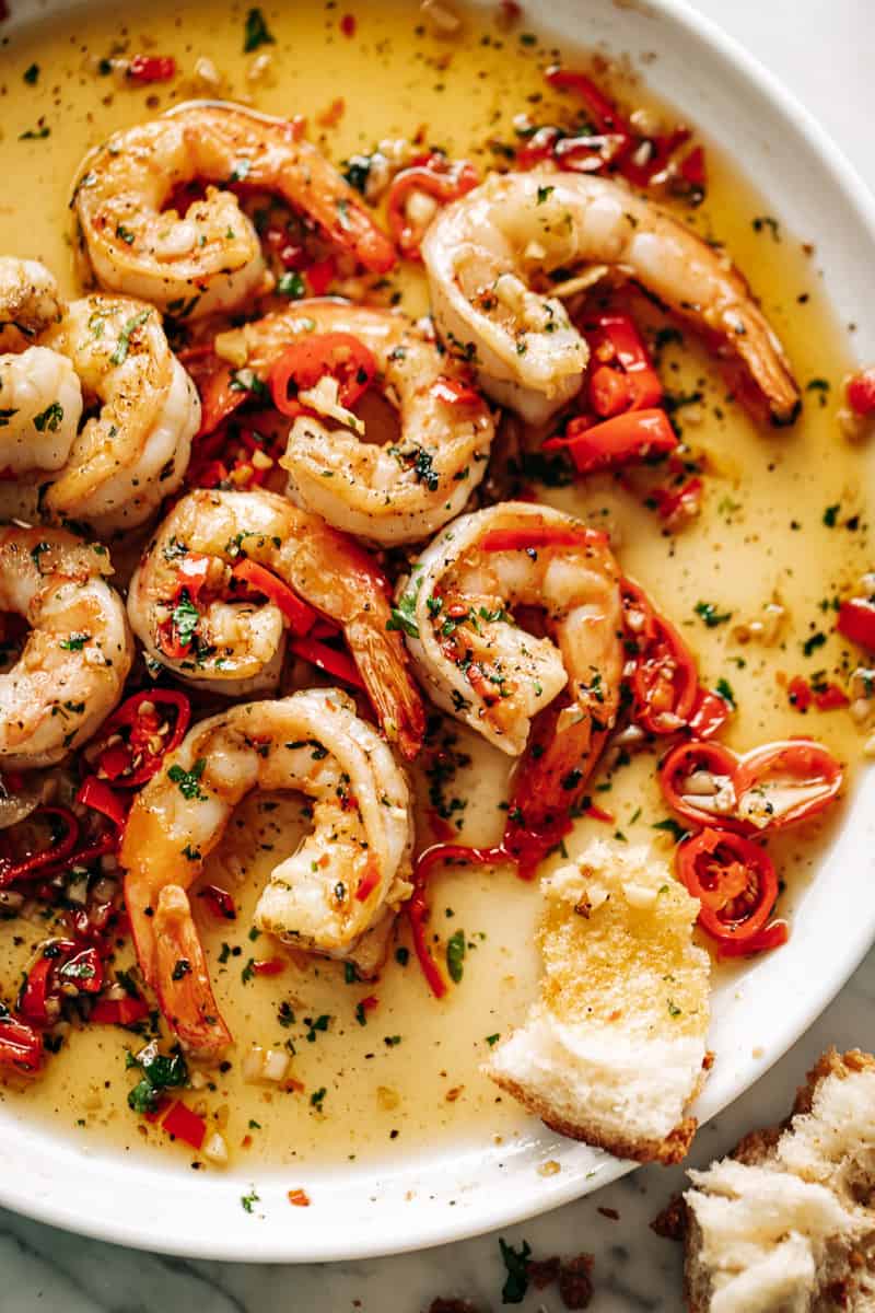 Image of a white plate with Chili Garlic Butter Shrimp in a buttery sauce