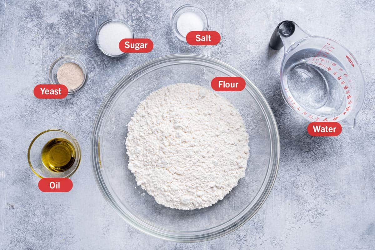 Image of all the ingredients needed for the preparation of this recipe, specifically: flour, oil, yeast, sugar, salt, and water