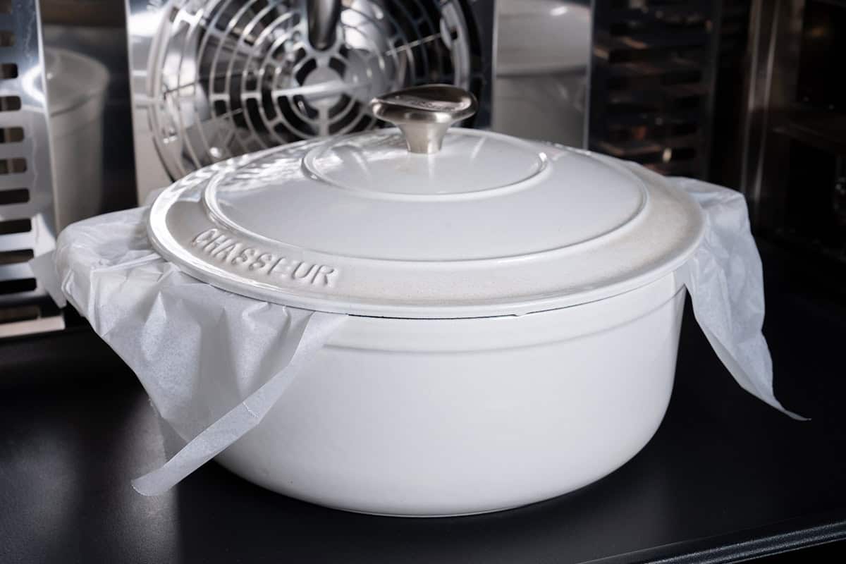 An image of the bread dough being placed inside the Dutch oven and baked for 30 minutes.