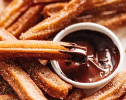 Churros dipped in a bowl of chocolate sauce | cafedelites.com