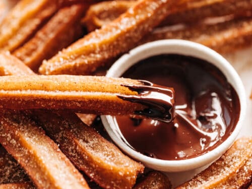 Churros dipped in a bowl of chocolate sauce | cafedelites.com