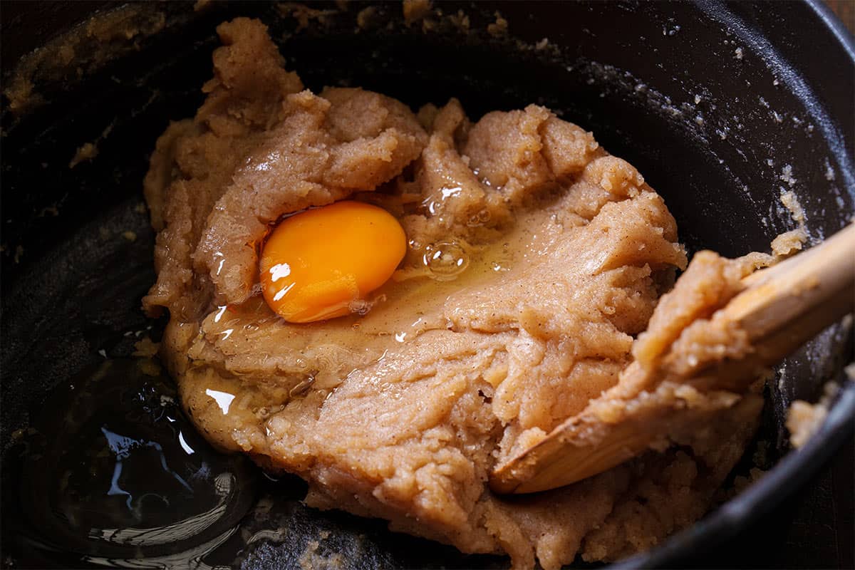 An image of the egg being incorporated into the dough before being stirred together and placed inside the sac à poche.