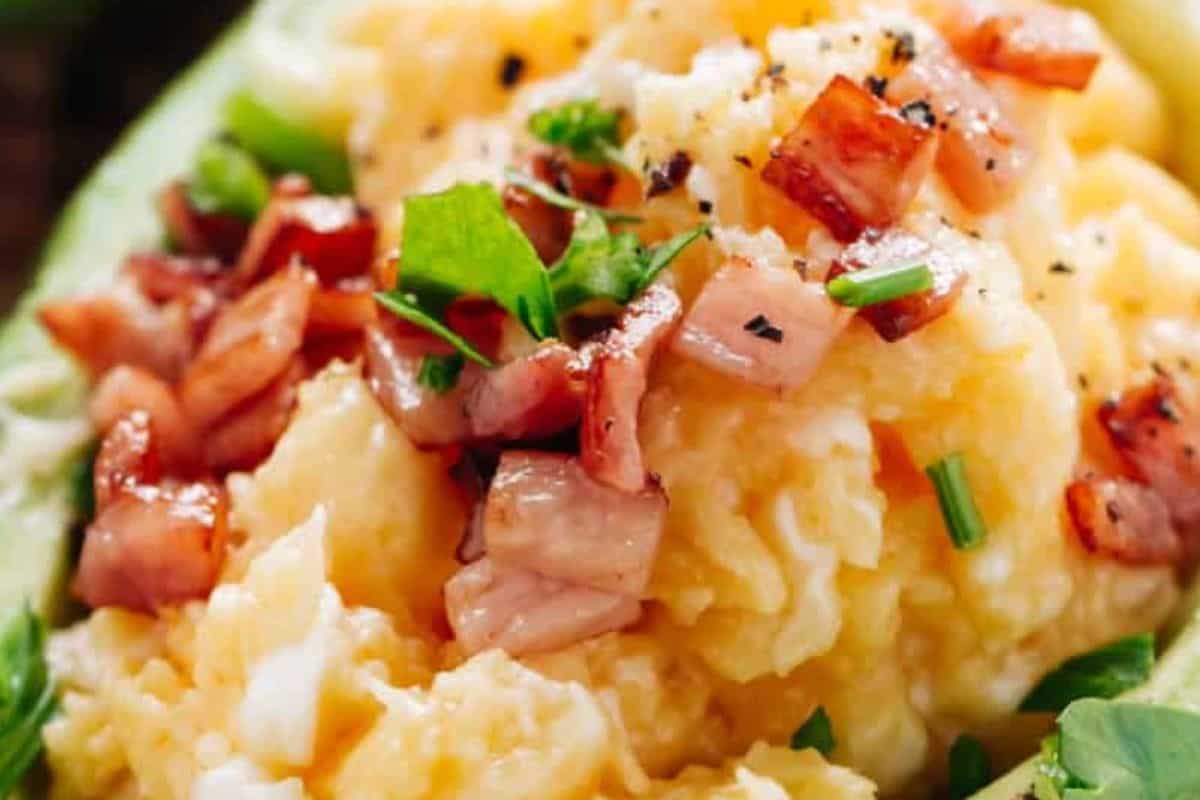 Spoon the eggs into the avocado boats, top with crispy bacon and fresh herbs. - 10