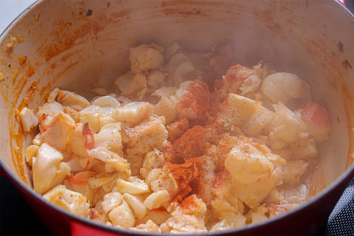 Chopped lobster chunks being added to the butter and sautéed for one minute.