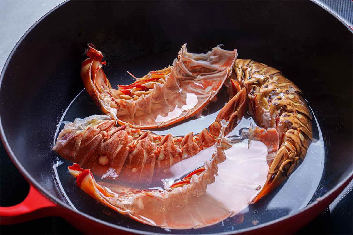 Lobster shells being returned to the pan to extract more of their distinctive flavor.