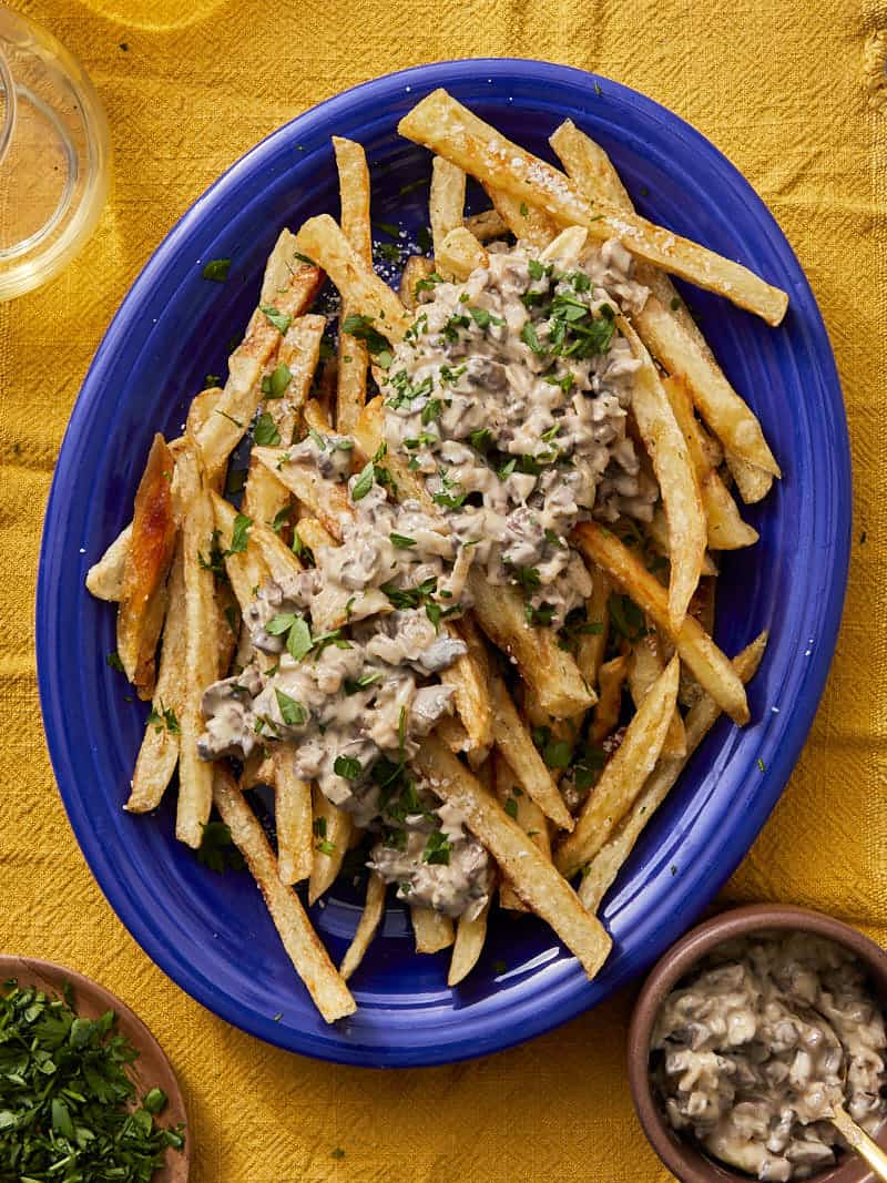crispy chips with a blue bowl topped with mushroom truffle sauce with parmesan