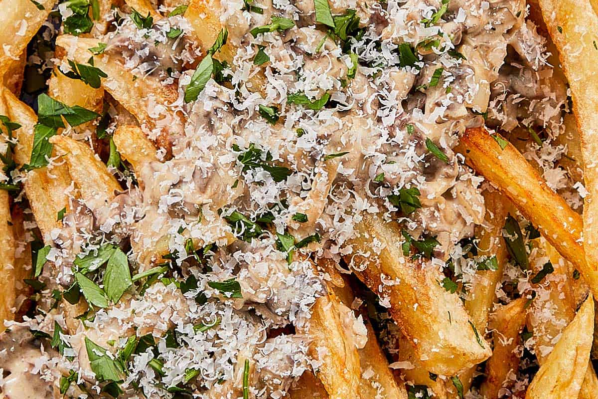 crispy chips with a blue bowl topped with mushroom truffle sauce with parmesan