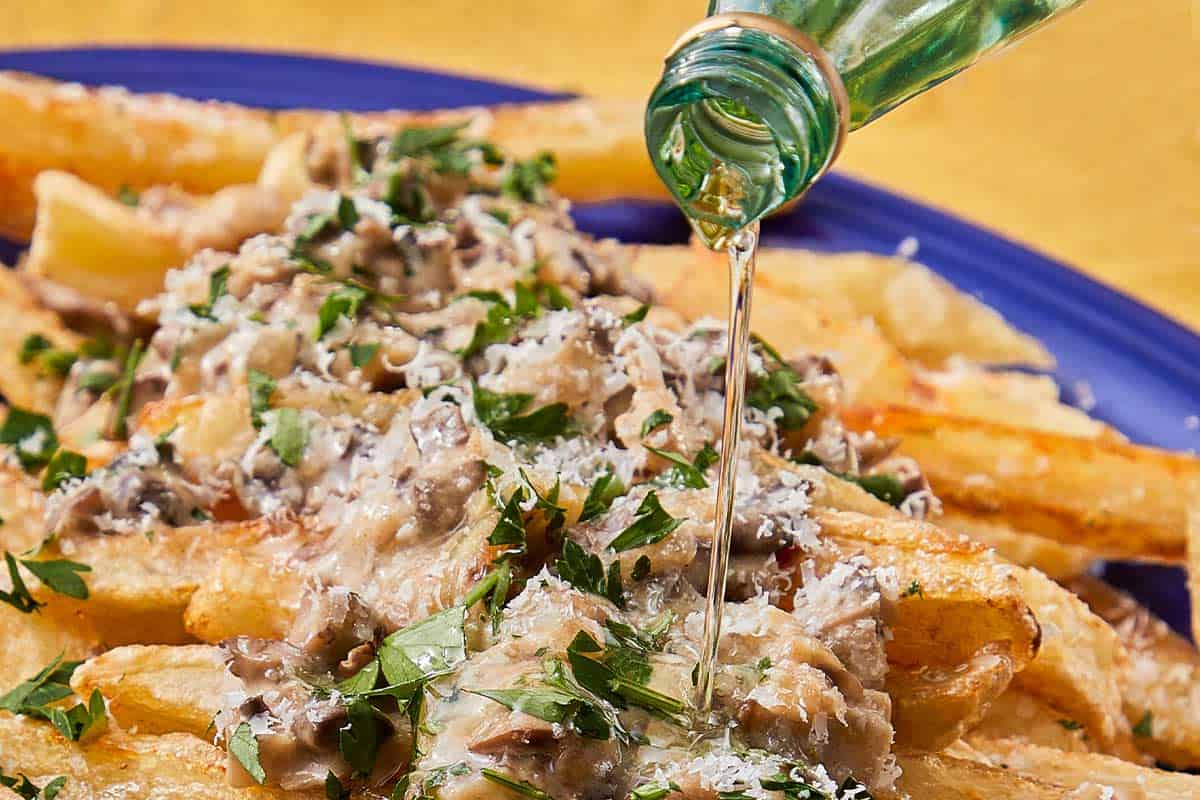 crispy chips with a blue bowl topped with mushroom truffle sauce with parmesan
