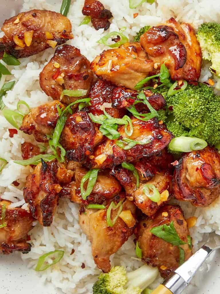Air fryer teriyaki chicken served over rice with broccoli and sliced green onions