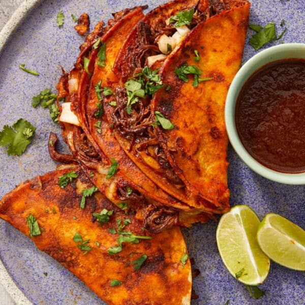 Crispy beef birria tacos with melty cheese and a rich red chile broth for dipping—bold, cheesy, and full of flavor.