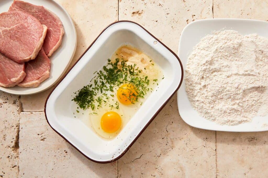 Eggs whisked with parsley, salt, and onion powder in a glass bowl
