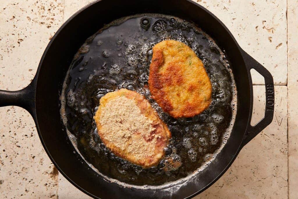 Beef milanesa frying in hot oil until golden and crispy