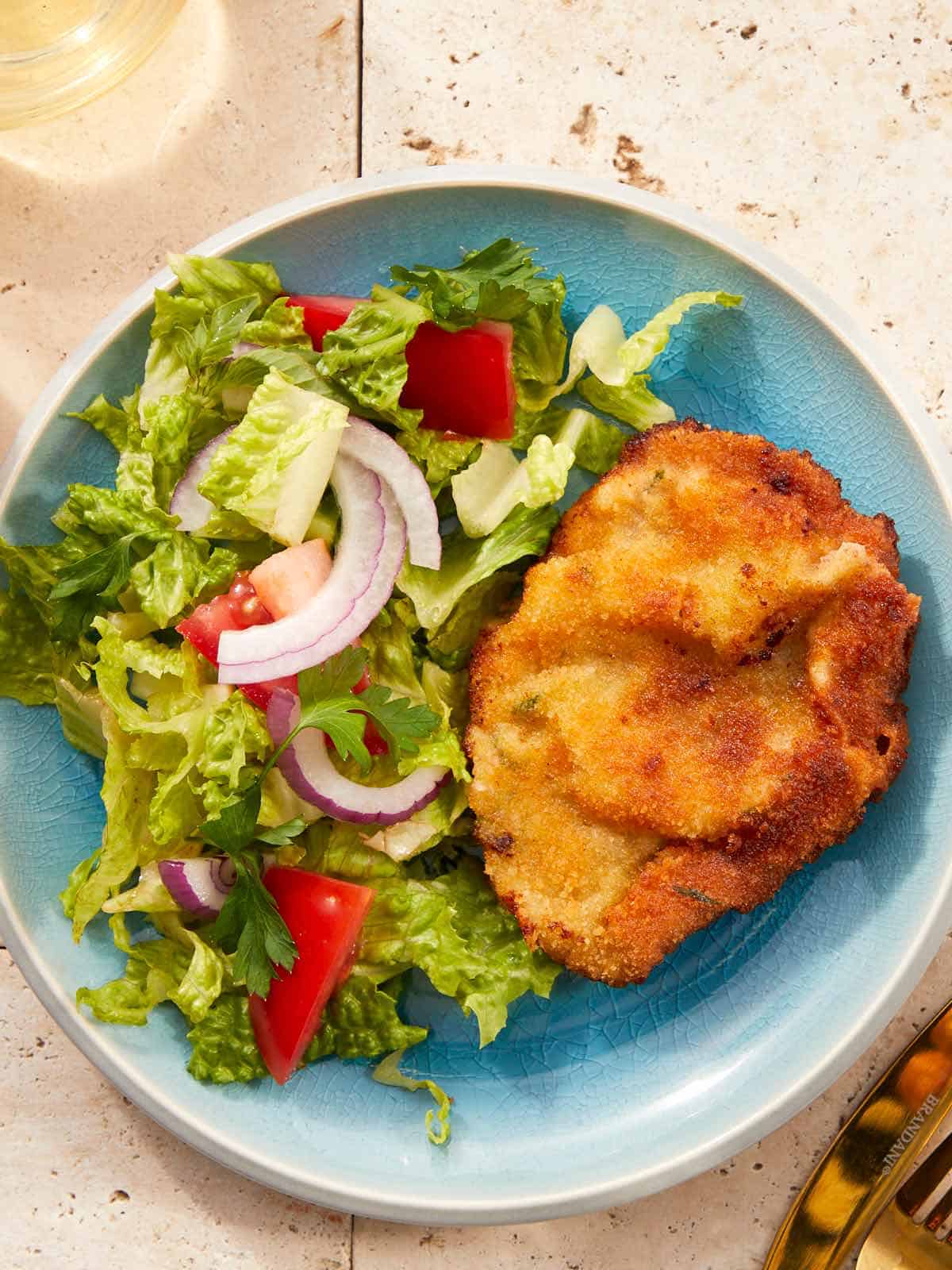 Crispy golden beef milanesa served with tomato salad.